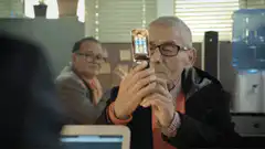 Seymour Hoffman flips open phone