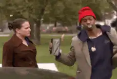 Man shows phone to woman in park