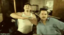 Two men dancing in a garage