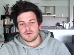 man in grey hoodie looking at camera