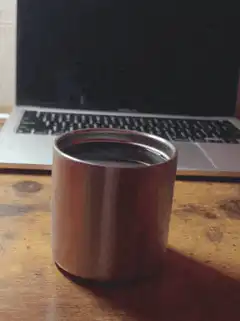 Metal cup on wooden desk