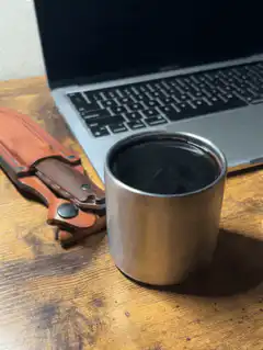 Coffee cup on desk with laptop and knife