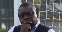 Man in vest thinking with hand on chin