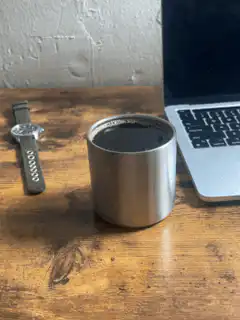Coffee cup on desk next to laptop