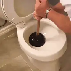 person plunging a toilet