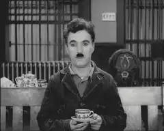 Charlie Chaplin holding a teacup