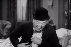 Man in bowler hat laughing hysterically