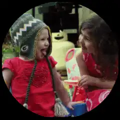 Toddler in green hat sticking tongue out