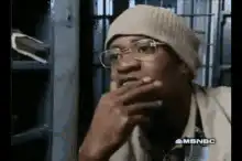 Man in beanie smoking and looking thoughtful