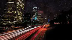 City skyline with starry sky and light trails