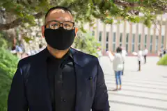 Man in suit and mask outdoors