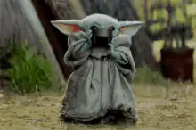 Baby Yoda drinking from a cup