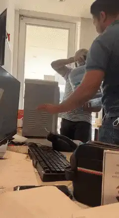 Man spills water cooler on desk