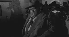 Man in hat looking around room