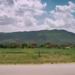 Man and child riding bicycle past mountains