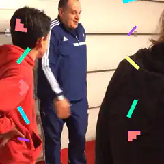 Man in blue tracksuit talking to kids