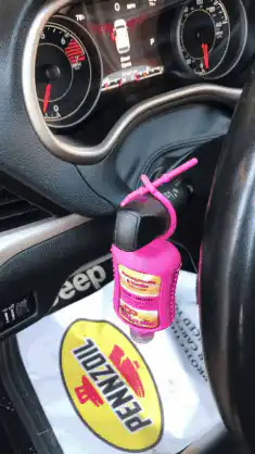 Pink hand sanitizer on car gear shift