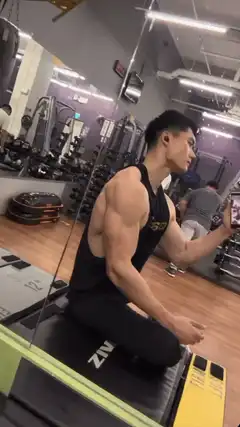 muscular man flexing in gym mirror