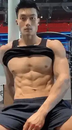 Muscular man flexing abs in gym