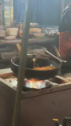 Street food wok tossing with flames
