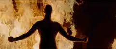 Man flexing in front of fire