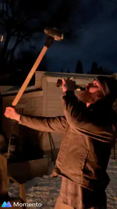 Bearded man balancing sledgehammer and beer