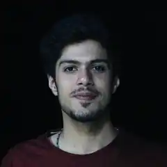 Man with goatee in dim light