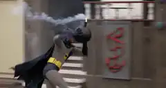 Batman throws a smoke bomb