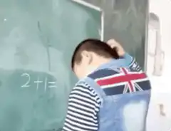 Boy writes 2+1=ok on chalkboard