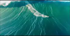 Surfer riding a massive wave