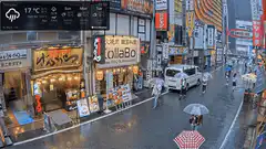 Rainy street scene in Japan with pedestrians and umbrellas