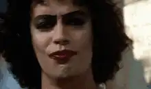 Person with dark makeup smirking