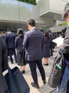 People in suits waiting outside building