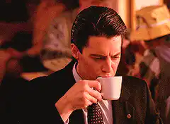 Kyle MacLachlan sipping coffee and smiling