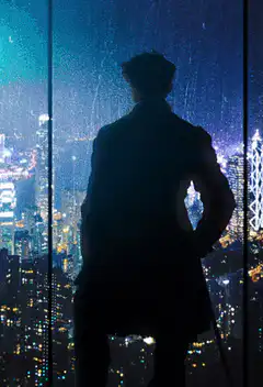 Silhouette looking out rainy city window