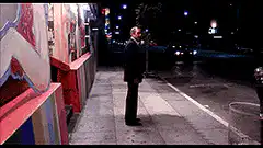 Man urinating on a wall at night