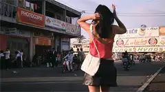 Woman fixing hair on busy street