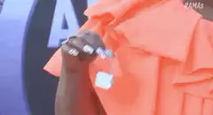 Woman in orange dress showing off diamond rings