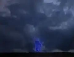 Blue lightning bolt strikes ground