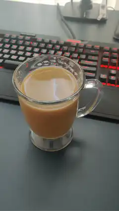 Hand gives thumbs up next to coffee