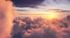 Flying through clouds at sunset