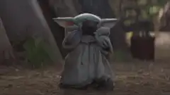 Baby Yoda drinking from a cup