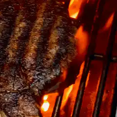 Steak sizzling on grill
