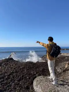 Man splashes ocean water on rocks