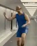 Man in blue outfit dancing in hallway