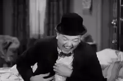 Man in bowler hat laughing hysterically