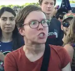 Woman with glasses making shocked face in crowd