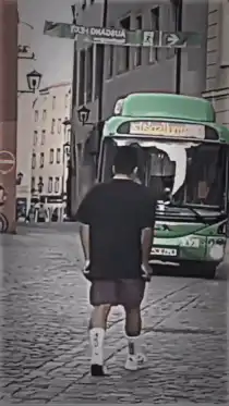 man dancing in front of bus