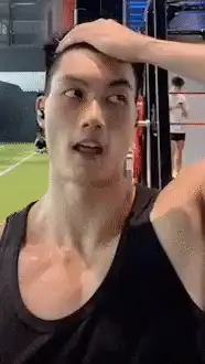 Sweaty man wipes sweat from forehead in gym
