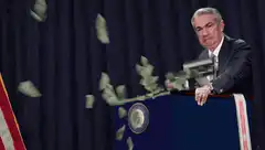 Jerome Powell throwing money from podium